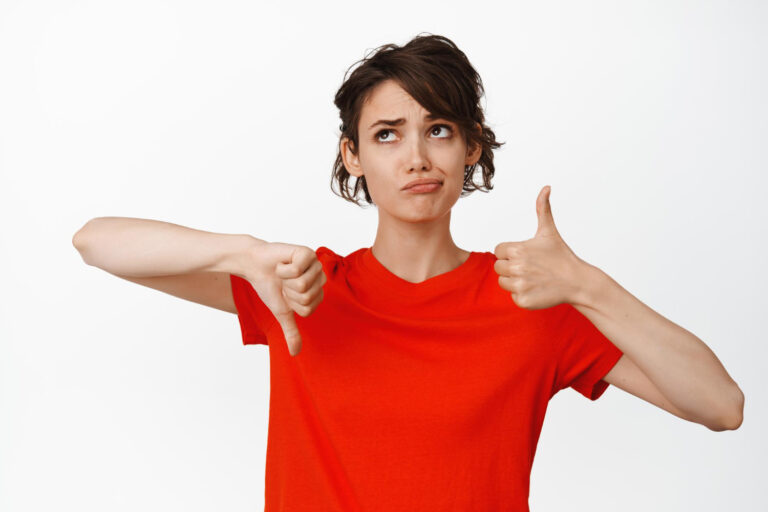 indecisive girl showing thumbs up thumbs down looking puzzled cannot make choice weighing pros cons white background 1